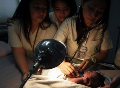 Nurses attend to a newborn baby found inside a bin at Manila's international airport, Philippines.