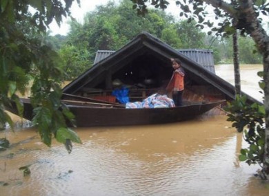 A girl stands on a boat in front of her flooded home in central Ha Tinh province, Vietnam