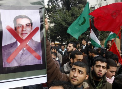 Palestinians wave Tunisian and Palestinian flags, and a portrait of deposed President Ben Ali, during a solidarity march in Gaza City yesterday.