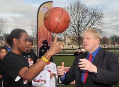 Mayor of London Boris Johnson learns basketball skills from Malcolm Jones, 16, of the Merton Hawks.