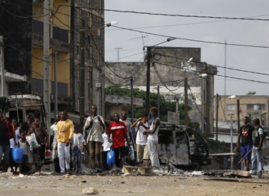 Civilians fleeing the violence pass a makeshift roadblock manned by youths armed with machetes and pipes on 27 February, 2010.