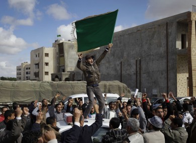 Pro-Gaddafi supporters stage a small rally during a state-arranged tour for foreign journalists yesterday.