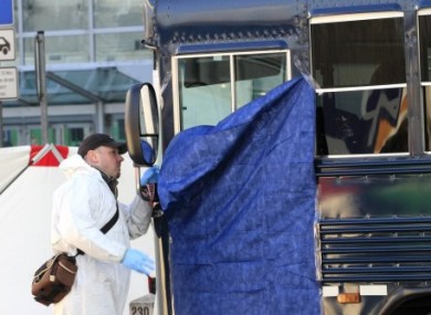 A police officer inspects the shattered windscreen of a bus outside Frankfurt Airport after a gunman opened fire on US soldiers on board today.
