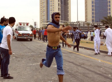 An anti-government protester clears the way for an ambulance during demonstrations in Manama yesterday.