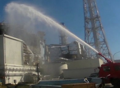 Image from the Japanese Defence Ministry showing a fire engine spraying water towards Reactor 3 on Friday.
