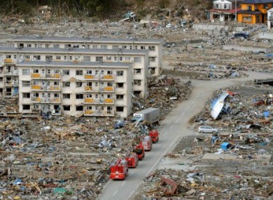Fire trucks go through a residential area of the Miyagi Prefecture, where police say over 15,000 people may have died.