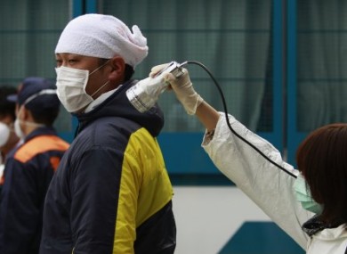 A man is screened for radiation exposure from Fukushima at an evacuation centre yesterday.