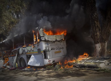A bus burns on the side of a road outside Benghazi today.