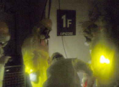 TEPCO employees work to restore power at the control room for Reactors 1 and 2 on Wednesday.