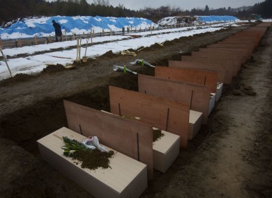Coffins are lined up at a mass grave site in Higashimatsushima, Japan, today.