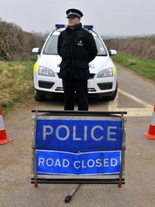 A policeman pictured near the site where the two bodies were found in Gloucestershire.