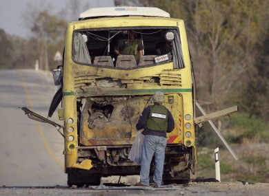 Israeli sappers inspect a school bus hit by an anti-tank missile fired from the Gaza Strip near the border between southern Israel and Gaza.