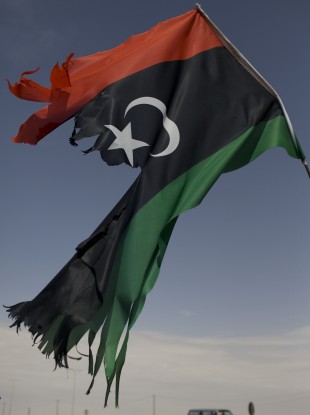 The remains of a Libyan rebel flag flutters in the outskirts of Ajdabiya, Libya on Friday.
