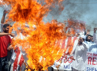 Pakistani protesters burn a representation of the US flag during a rally to condemn US drone attacks in Pakistani territory on Friday.