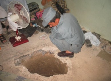 An Afghan policeman inspects the entrance to the prison escape tunnel.