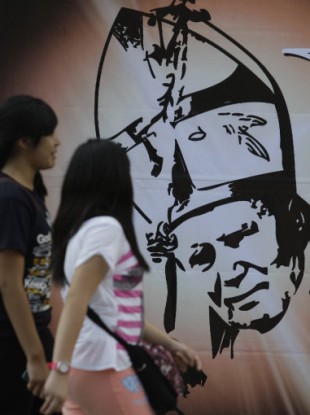 Two girls look at an image of the late Pope John Paul II in Manila, Philippines.