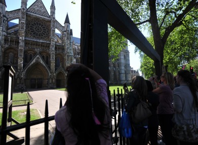 Tourists take photos of the exterior of Westminster Abbey. There will be nothing to stop guests doing the same inside the Abbey tomorrow