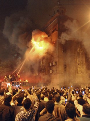 Firemen fight a fire at a church surrounded by angry Muslims in the Imbaba neighborhood in Cairo
