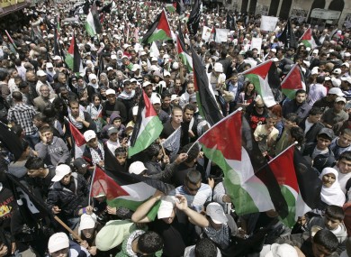 Demonstrators wave Palestinian flags during a rally in the West Bank city of Ramallah on Sunday.