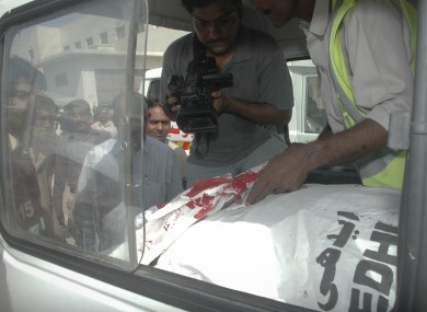 A Pakistani cameraman records video of a Saudi consulate employee who was shot dead in Karachi, Pakistan on Monday.
