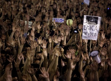 Demonstrators rise their hands as they shout slogans during a protest at Sol square, in Madrid on Friday.