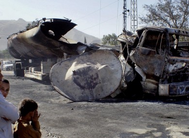 Local children survey the damage to the burnt out oil tanker.