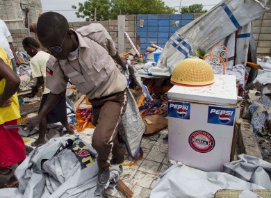 A municipal worker carries away a tent used by a family during an eviction at an earthquake displaced camp in Port-au-Prince, Haiti.