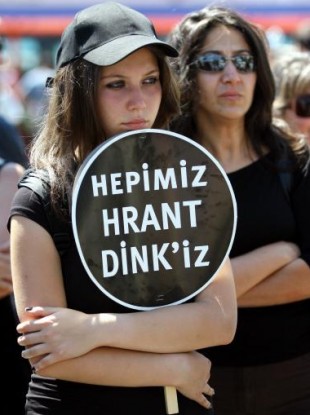 A demonstrator holds a placard that reads: