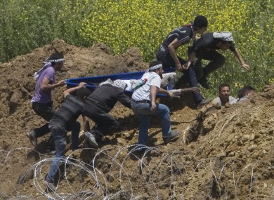 Protesters attempt to rescue a man shot by Israeli troops along the Syrian border on Sunday.