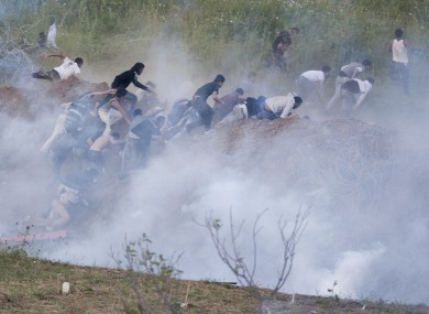 Protesters retreat from the border after Israeli forces fired tear gas yesterday.