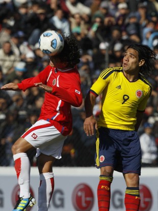 Costa Rica's Randall Brenes, left, heads the ball as Colombia's Radamel Falcao looks on.