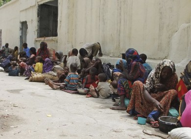 Somalis wait outside a building as they wait to go to an internally displaced camp in Mogadishu.