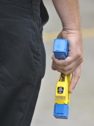 A police officer holds a Taser gun.