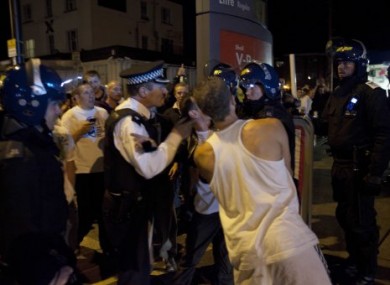 Police scuffle with men who say they are protecting their homes in Enfield, London, on Tuesday night.