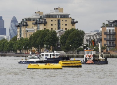 An emergency life boat, right, floats on the River Thames where a tugboat capsized and sank at Greenwich last week.