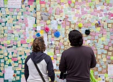 Notes are pinned up at a 'Peace Wall' on a boarded-up window of the Poundland store on Rye Lane, Peckham, which was destroyed during last week's riots.