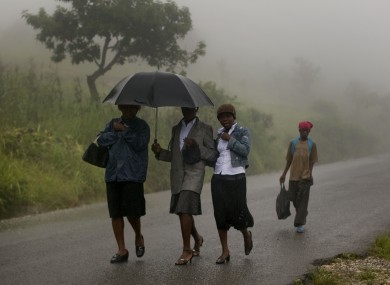 People in Haiti try to take shelter from the rain coming from Hurricane Irene. The hurricane is set to make landfall in the Bahamas and in the US in the next two days.