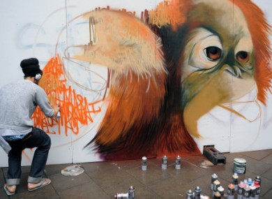 A graffiti artist at work in the See No Evil street art project in Bristol today.