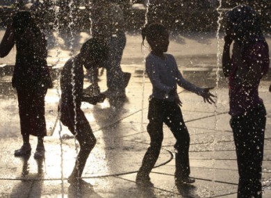 File photo: Iranian children play in a fountain during high temperatures last month.