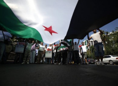 Syrians living in Greece raise up a huge Syrian flag during a protest in Athens against the suppression of protesters.