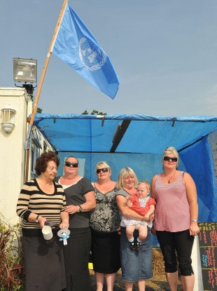 Members of the McCarthy family below a UN flag been flown at the Dale Farm site in Essex yesterday.