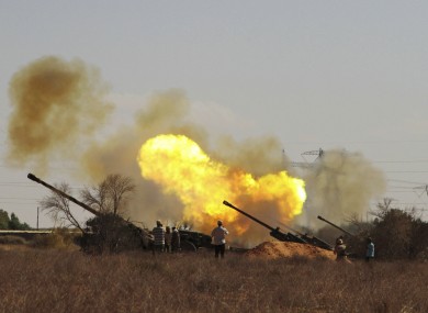 Libyan fighters fire canons toward pro-Gaddafi forces from the western outskirts of Sirte yesterday.