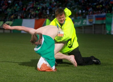 An Irish fan is tackled by a steward during the game against Russia.
