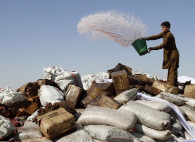 A man pours petrol over a pile of confiscated drugs and alcohol in Afghanistan