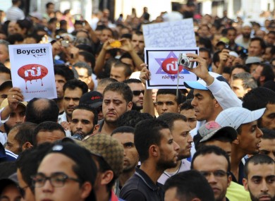 Radical Islam followers demonstrate, some holding a picture of a defaced logo of a television channel, after Friday prayer in Tunis.