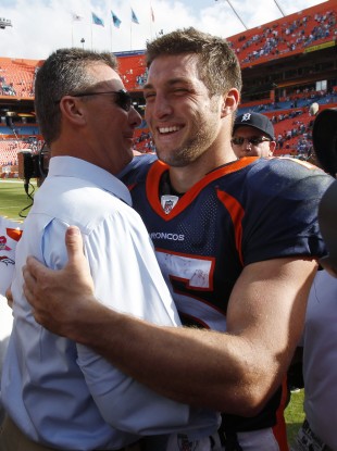 Tim Tebow, right, gets a hug from his college coach at Florida, Urban Meyer, after the Broncos defeated the Miami Dolphins 18-15 in overtime on Sunday.