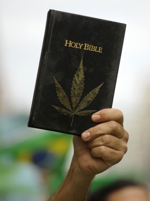 A man holds a bible covered by an image of a cannabis leaf during a march in favor of the legalization of marijuana in Sao Paulo, Brazil (File)