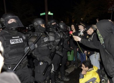 Occupy Portland protesters offer riot police a rose.