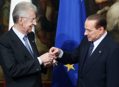Silvio Berlusconi presents Mario Monti with a small ceremonial bell - used by prime ministers to call cabinet meetings to order.