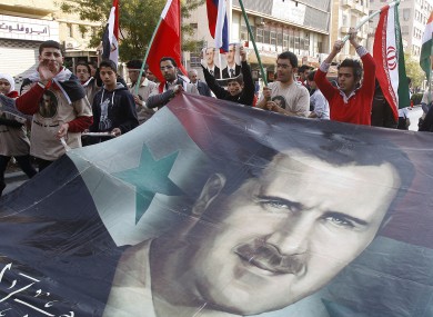 Pro-Syrian regime protesters shout slogans and carry a huge portrait of the Syrian president Bashar Assad during a protest against the Arab League decisions, in Damascus
